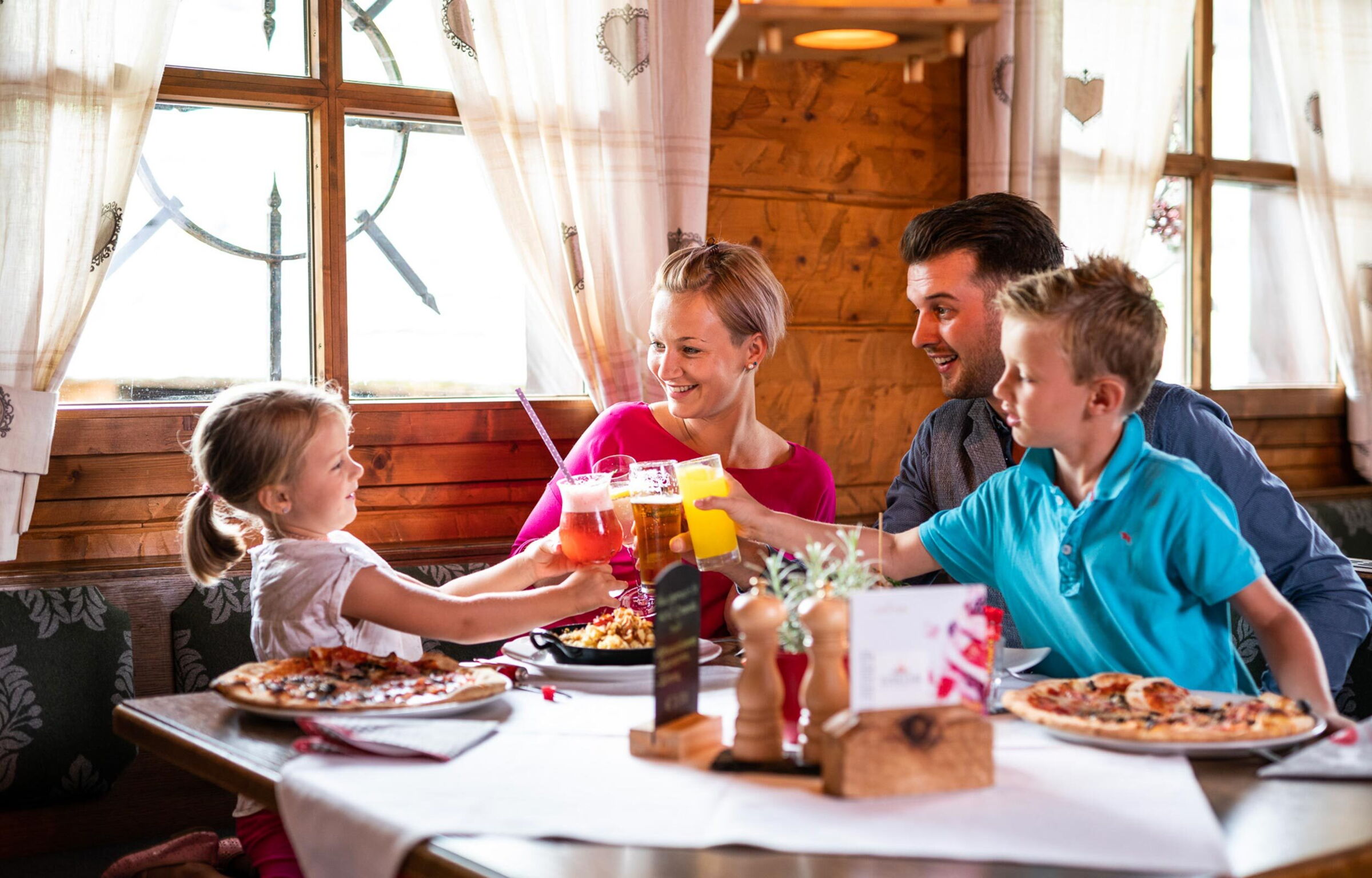 Una famiglia si siede in una capanna e brinda con le bevande